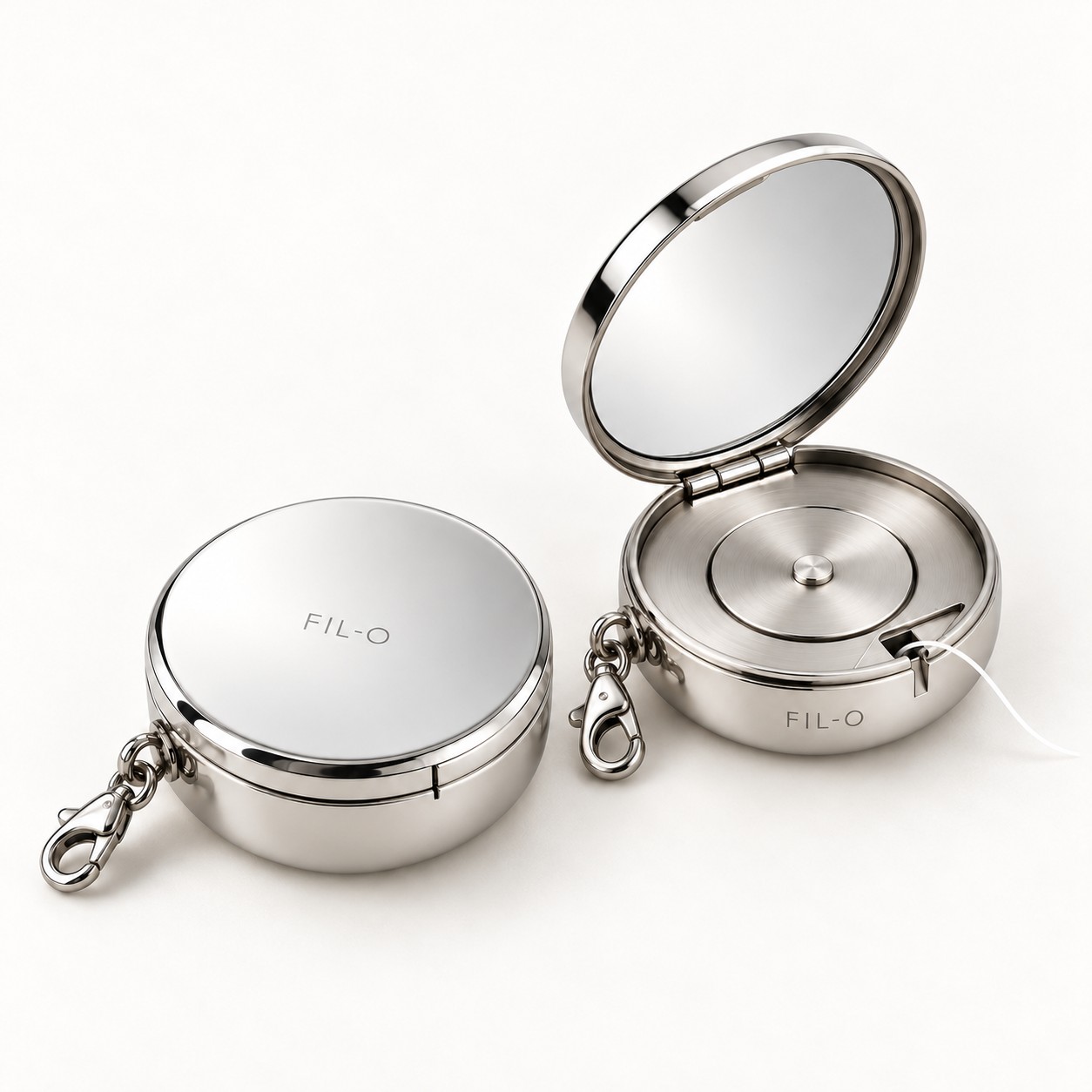 Two FIL-O polished steel compacts, one closed and one open showing the mirror and floss